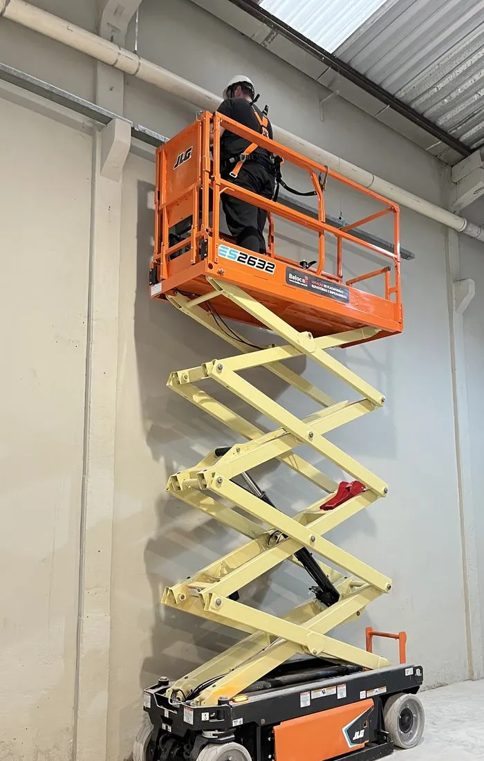 Marcos no alto de uma plataforma elevatória, com equipamento de proteção