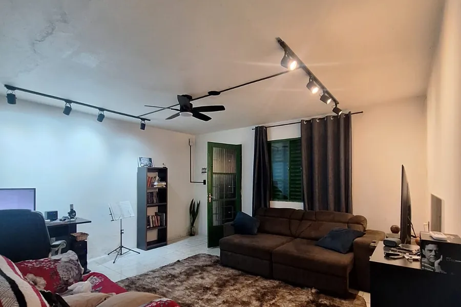 Sala com dois trilhos de spots e ventilador de teto